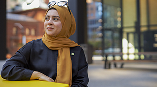 A TD colleague smiles as they welcome a customer into a branch to discuss their finances.