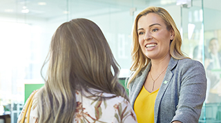 A customer meets with a female TD colleague to discuss financial options at a TD branch.