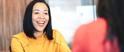 A businesswoman smiles while meeting with a TD procurement officer.