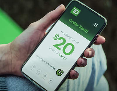 Hand holding phone with TD App on screen